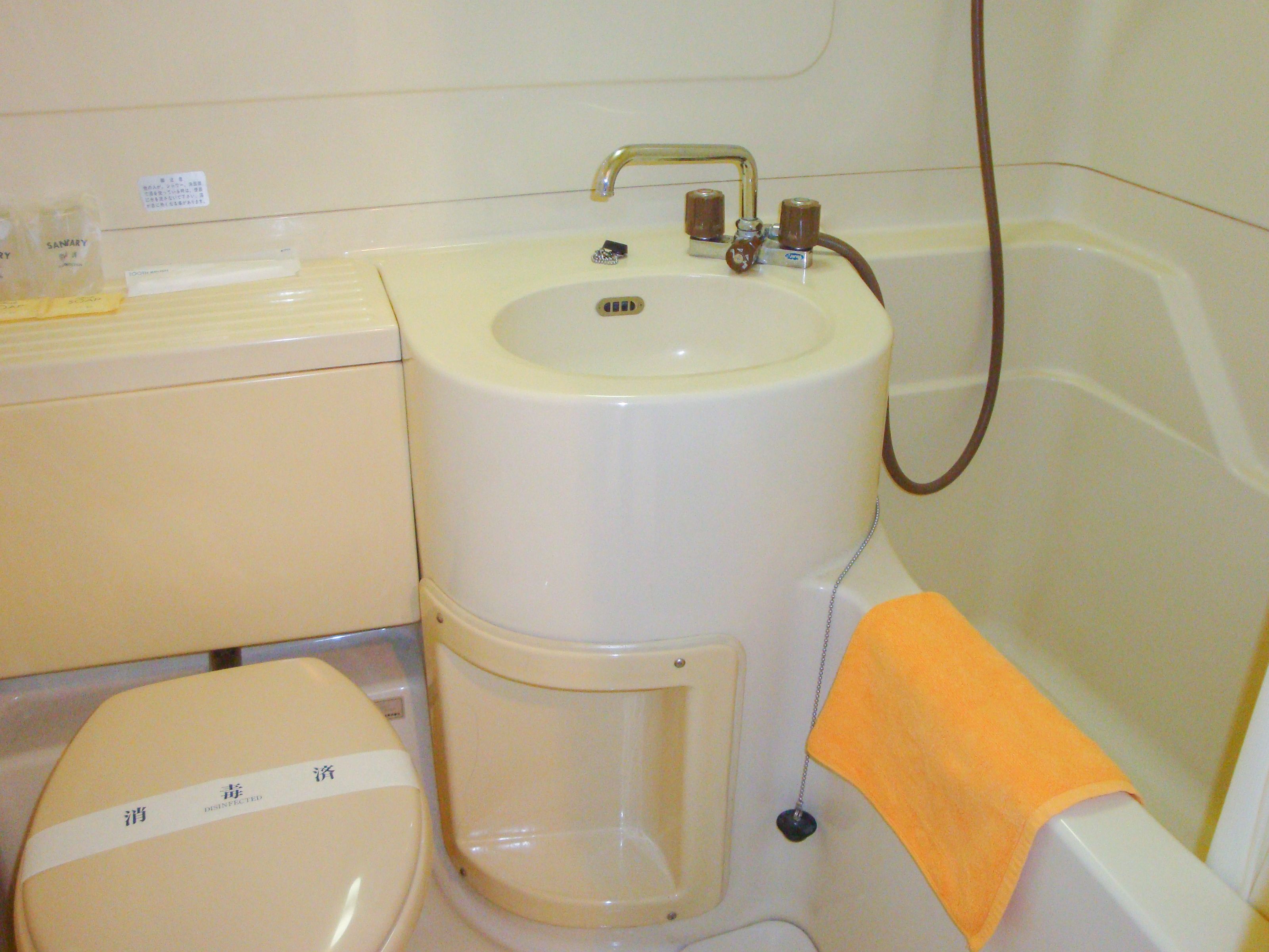 A bathroom with a toilet, sink, and bathtub.