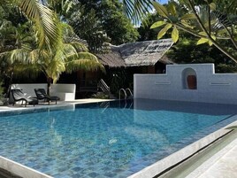 Una piscina al aire libre, tumbonas