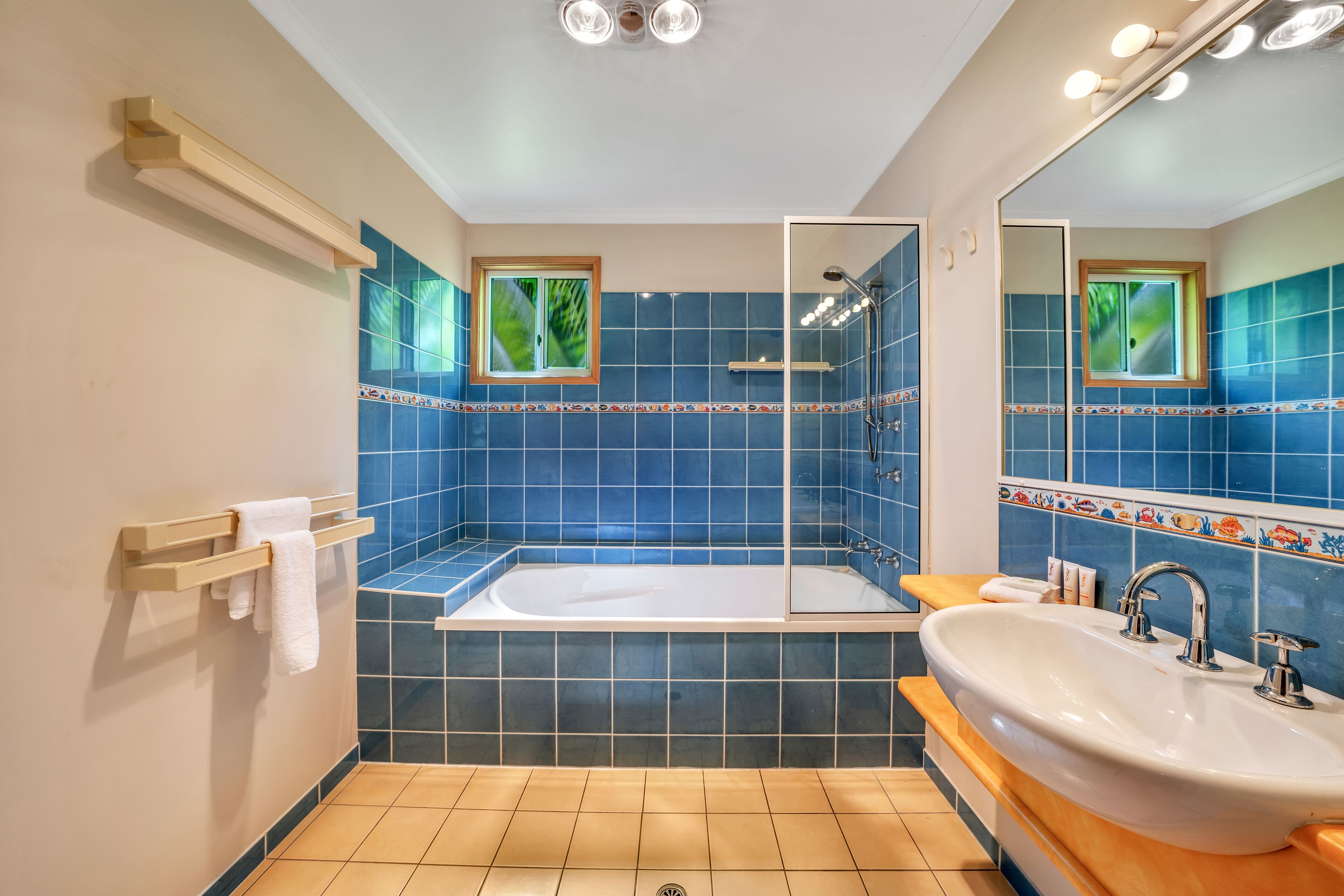 A bathroom with a bathtub, a sink, and a shower area.