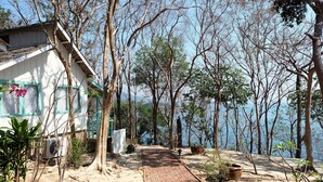 A pathway leading to a building with a view of the sea. - The C Samet Beach Resort (Rayong)