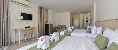 Habitación de hotel con cama, escritorio, silla, televisión y baño a la vista.