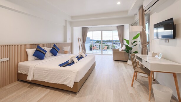 A hotel room with a bed, a desk, a TV, and a balcony with a view. - Little Home Ao Nang (Krabi)