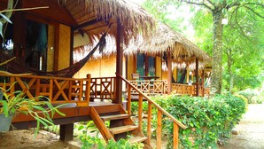 A wooden structure with a thatched roof, a wooden staircase, and a hammock.