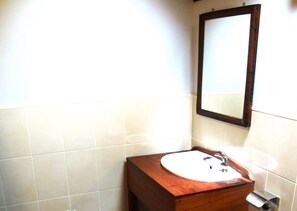 A bathroom with a wooden vanity, a white sink, and a mirror. - Villa De Pai (Pai)