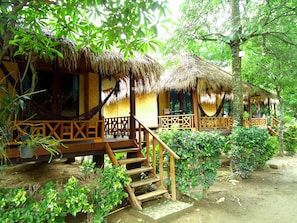 A thatched-roof bungalow with wooden railings and a hammock. - Villa De Pai (Pai)