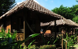 A rustic wooden structure with a thatched roof, surrounded by lush greenery. - Villa De Pai (Pai)