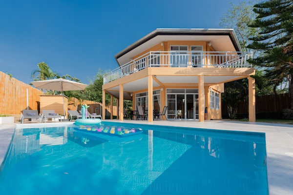 Una piscina al aire libre, sillones reclinables de piscina