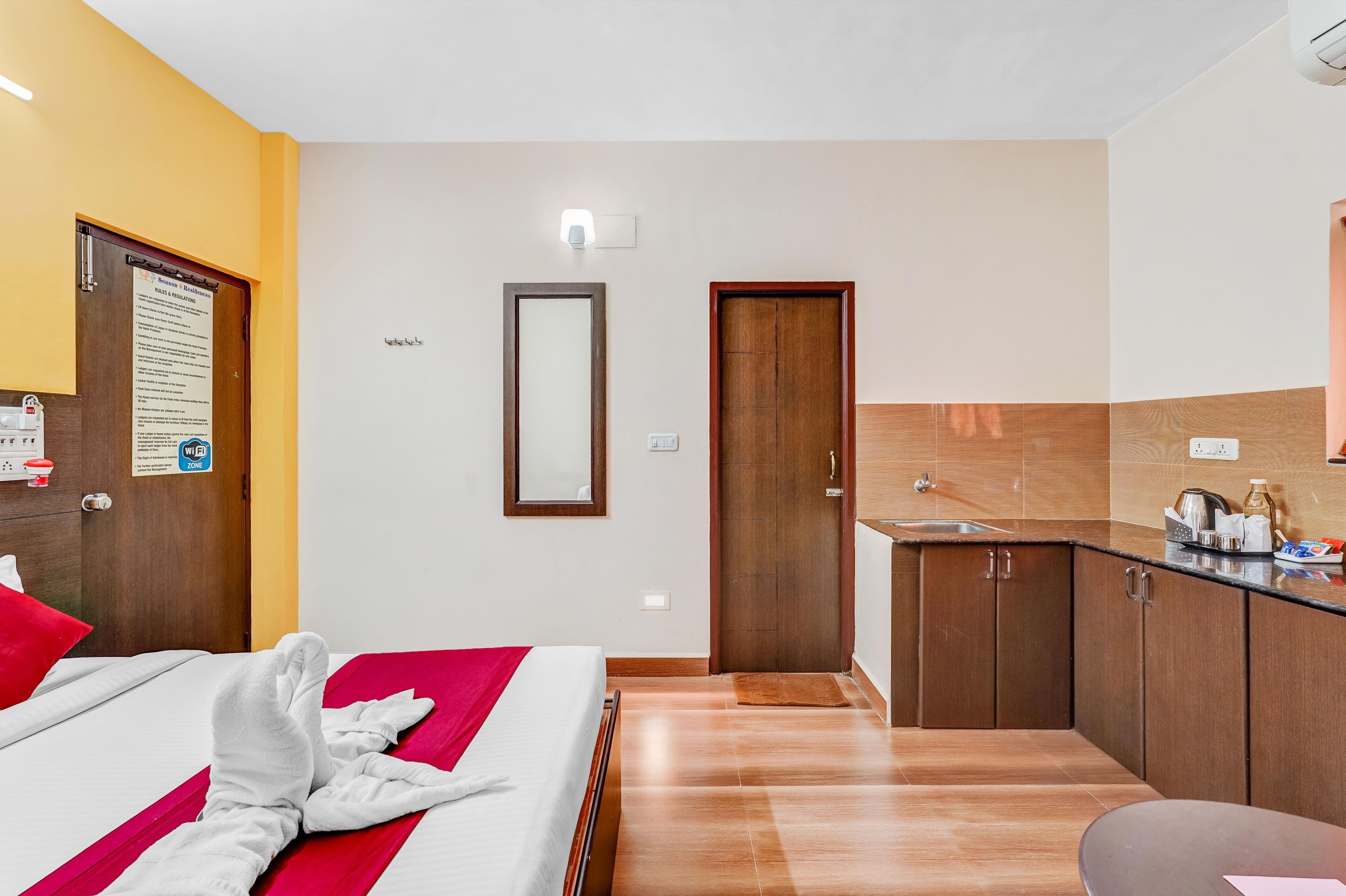 Une chambre d’hôtel avec un lit, une petite kitchenette et une salle de bain.