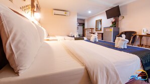 Habitación de hotel con una cama grande, un escritorio, una silla, un televisor de pantalla plana y un minibar.