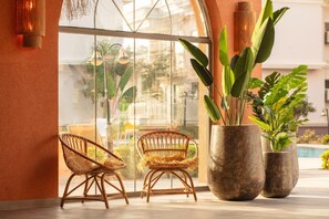 A room with large windows, wicker chairs, and potted plants. - Defne Beach Makri (Fethiye)