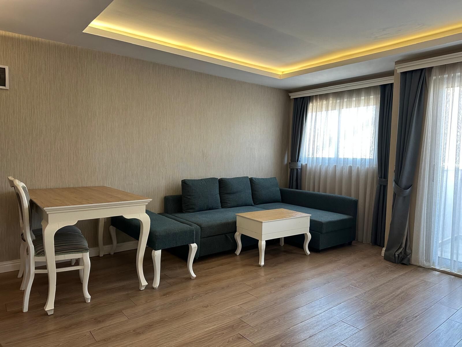 A modern living room with a sofa, a dining table, and a small coffee table.