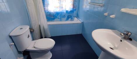Un baño con inodoro, lavabo y bañera.