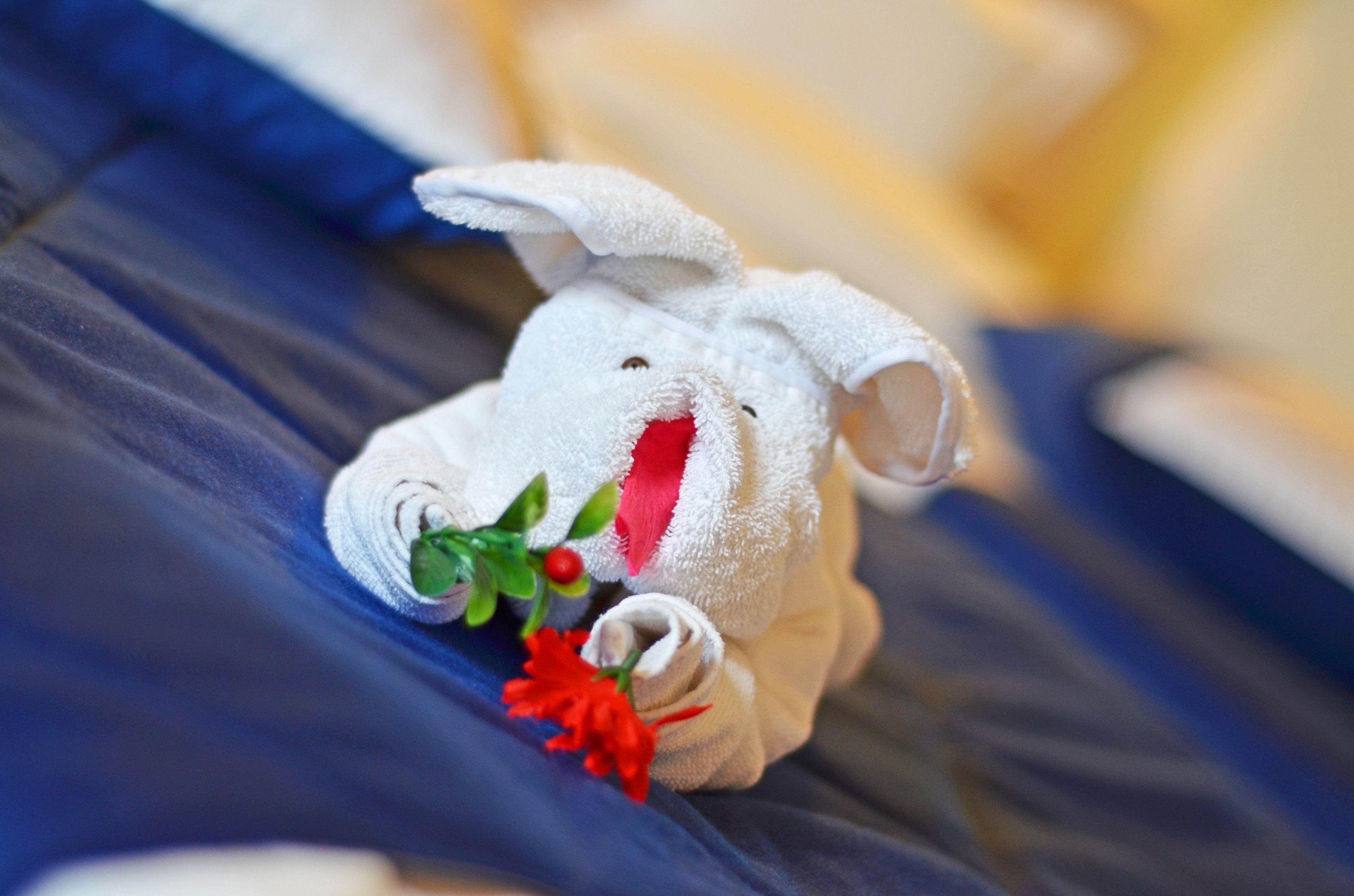 Un conejo de peluche sobre una cama con una manta azul.