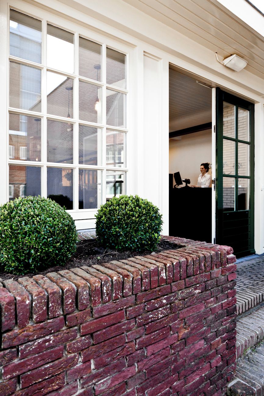 A building with a large window, a brick wall, and a person at a desk.