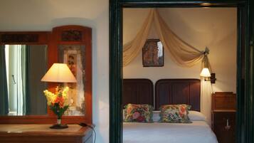 A bedroom with a bed, a nightstand, a lamp, a dresser, and a mirror.