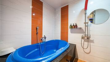 Standaard kamer | Badkamer | Een aparte badkuip en douche, een diep bad, gratis toiletartikelen