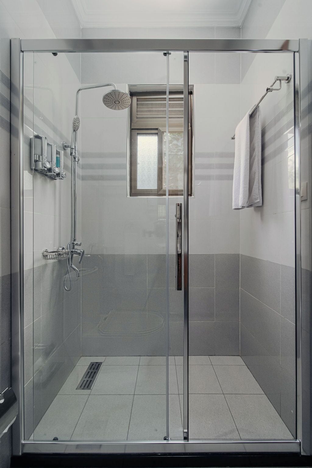 Un bagno doccia vetrato con soffione a pioggia, doccetta manuale e getto orientabile.