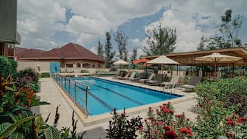 Een buitenzwembad, parasols voor strand/zwembad