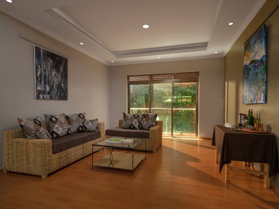 Amplia sala de estar con un conjunto de sofás, una mesa de centro y una mesa de comedor con vistas a través de puertas de vidrio grandes.