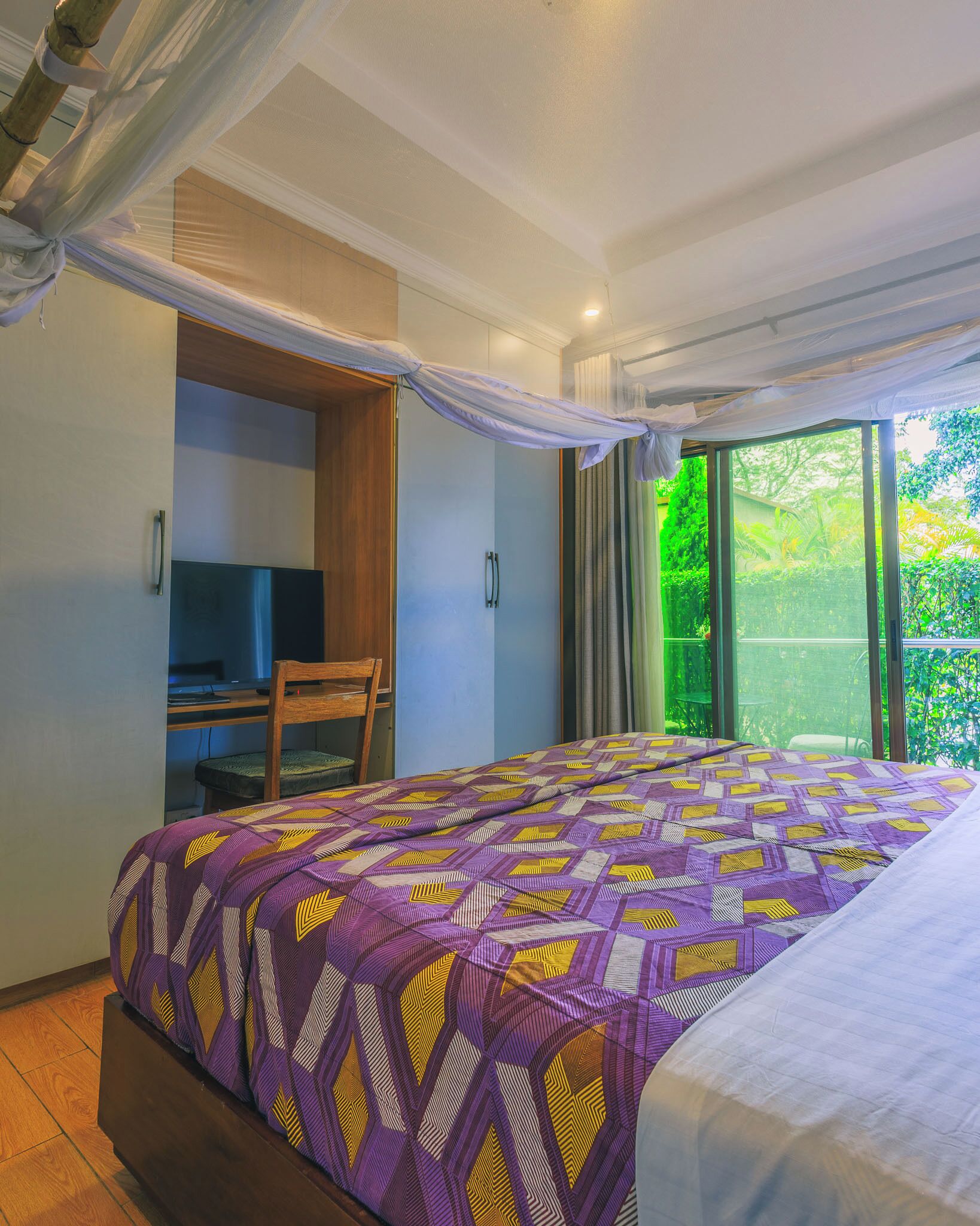 A bedroom with a bed, a desk, and a chair.
