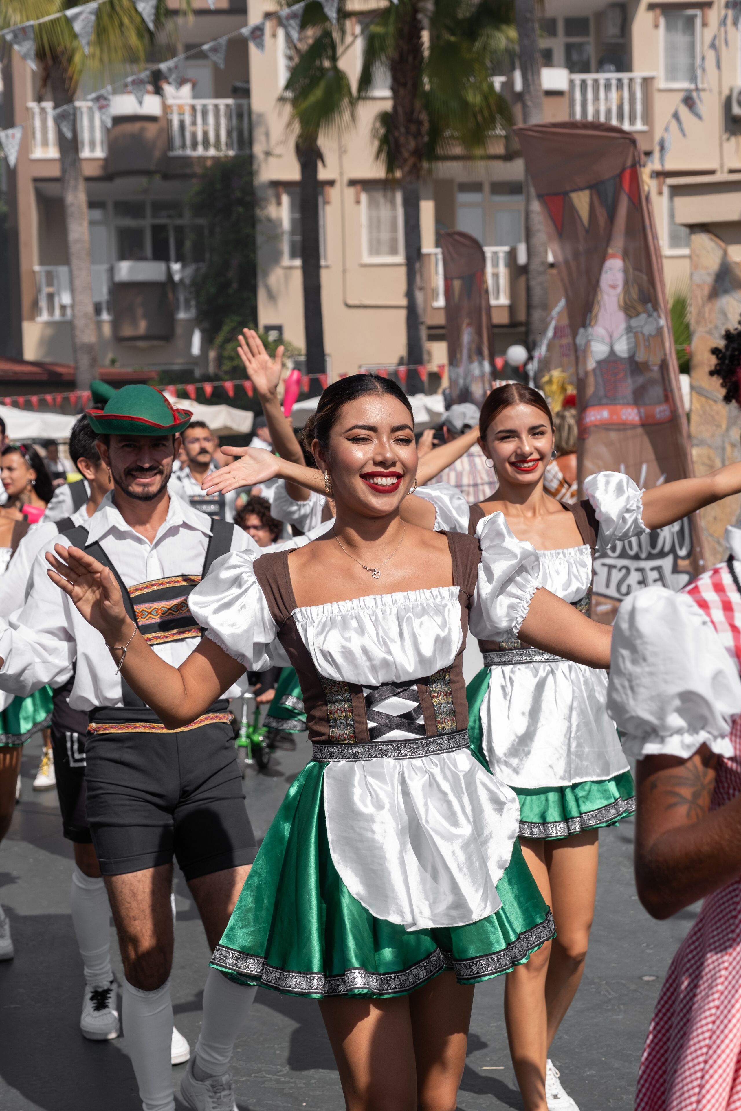 Un grupo de personas vestidas con atuendos tradicionales, posiblemente en un evento cultural, con edificios al fondo.