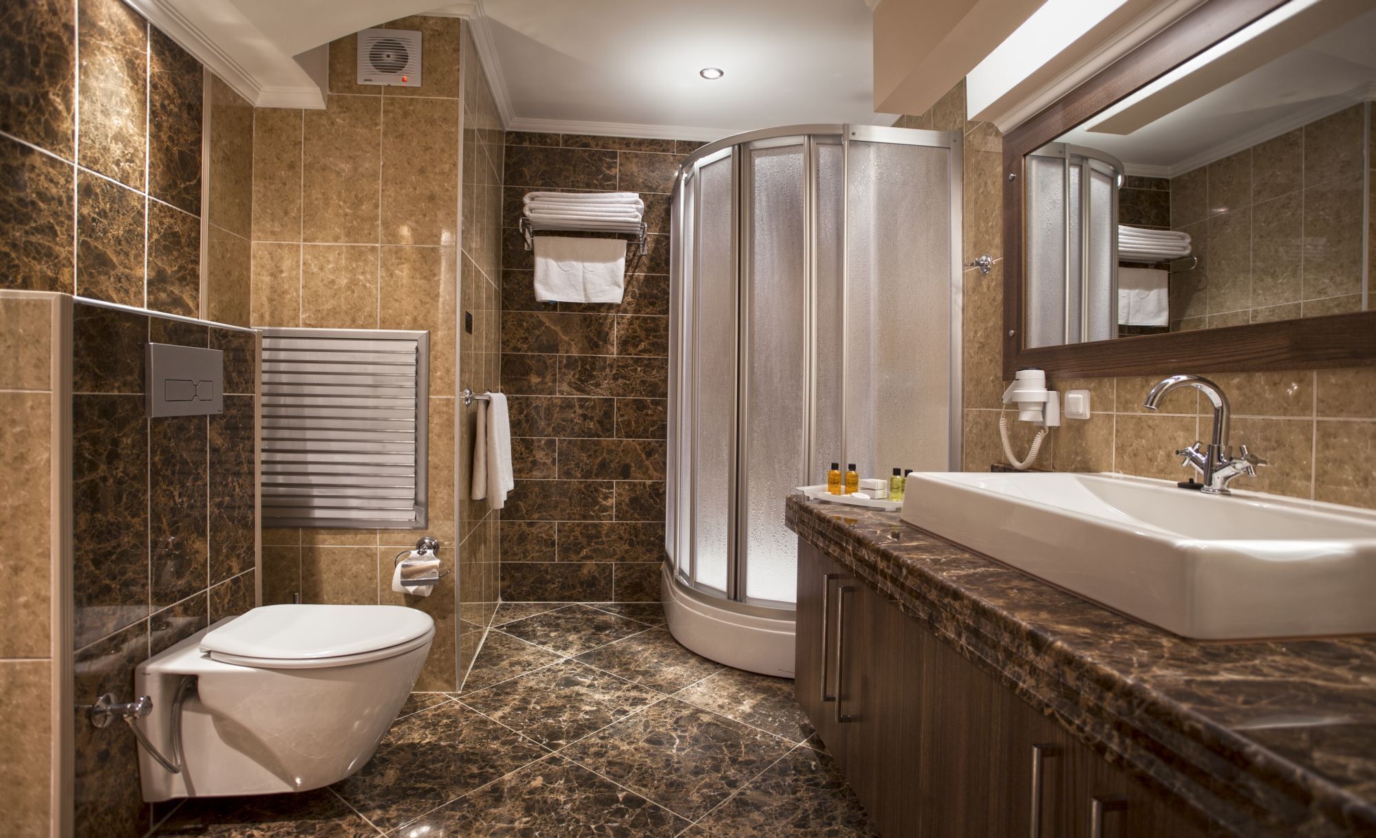 Un bagno moderno con doccia, servizi igienici e lavandino.