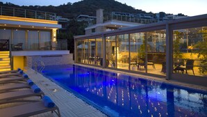A modern pool area with lounge chairs and a glass-enclosed patio. - Spektr Boutique Hotel Yalıkavak (Bodrum)