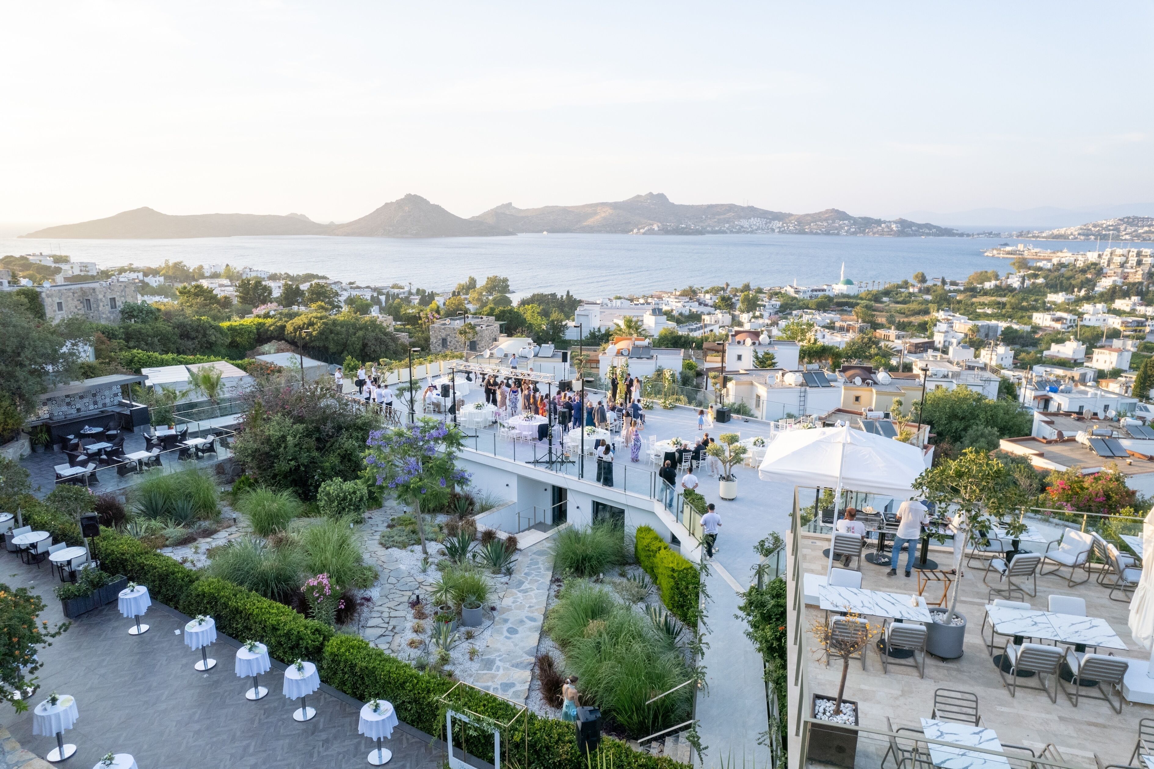 Une terrasse sur le toit avec des sièges extérieurs, une vue sur la mer et un panorama de la ville en arrière-plan.