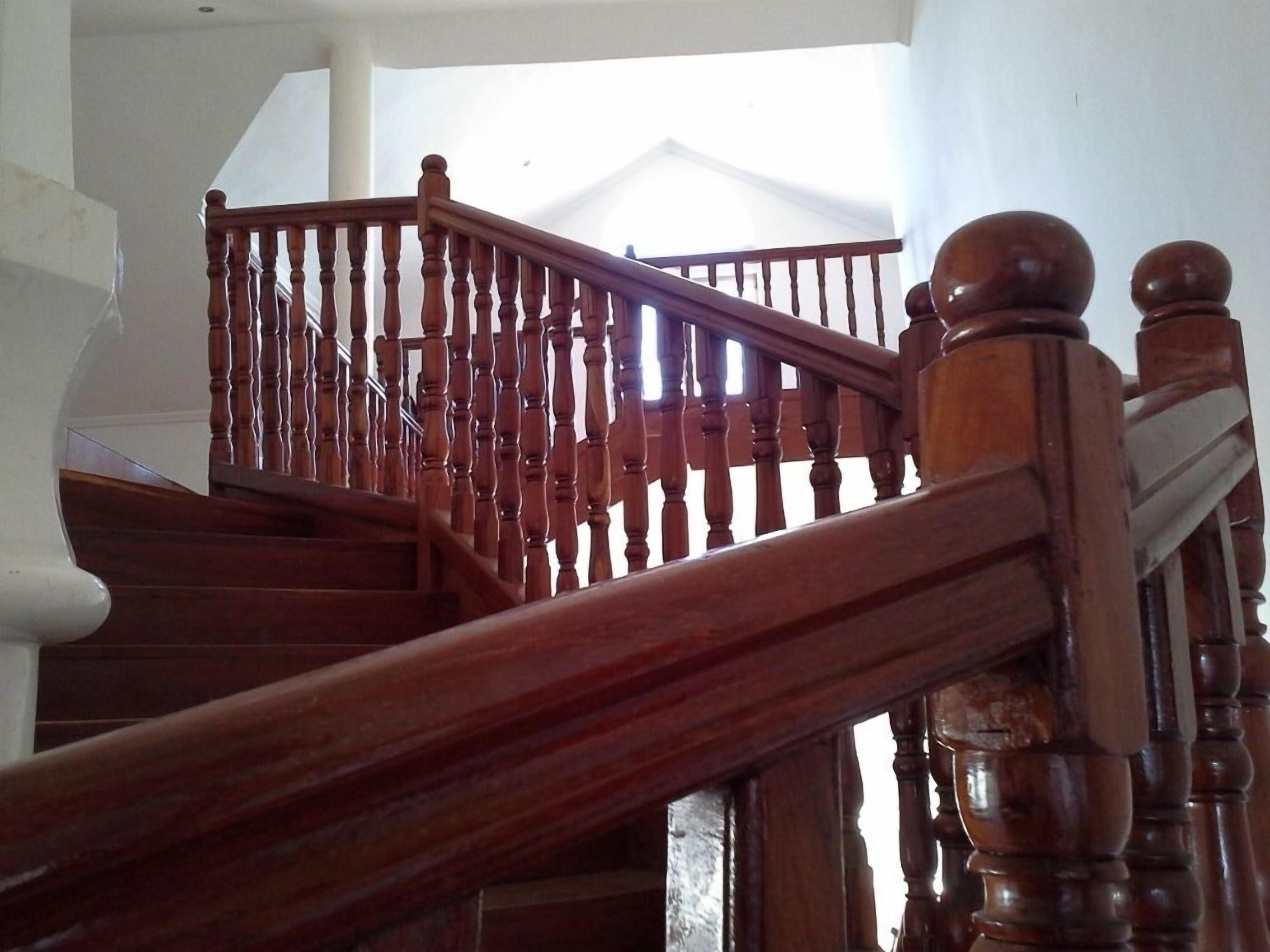 A wooden staircase with a handrail and balusters.