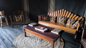 Un canapé en bois avec des coussins à motifs, une table basse en bois et un tapis tissé.