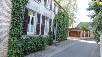 A two-story building with ivy-covered walls and wooden shutters.