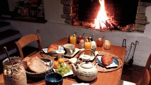 A breakfast table with bread, eggs, juice, and a teapot. - B&B Le Valangré (Chaumont-Gistoux)