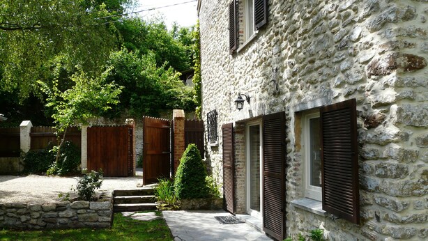 A stone building with a stone pathway leading to a wooden gate. - B&B Le Valangré (Chaumont-Gistoux)
