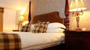 A neatly made bed with plaid bedding and two bedside lamps.