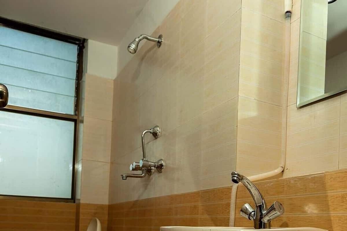 A bathroom with a toilet, sink, and shower.