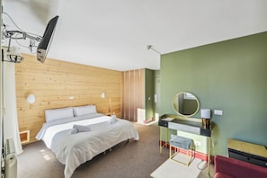 Un dormitorio con cama, mesita de noche, espejo y una silla roja.