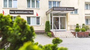 Un edificio con letreros que indican 'Dom Spółdzielczosci Pracy' y 'Szkoleństwo Moncenicy Brzeżno'.