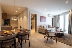 Ein modernes Wohnzimmer mit einer Couch, einem Couchtisch und einem Essbereich mit Stühlen und einem Tisch.