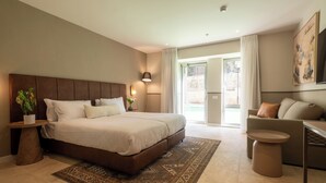 A modern bedroom with a large bed, a sofa, and a small table. - Hotel Beit Shmuel (Jerusalem)