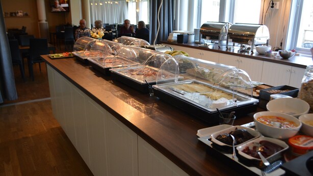 A buffet area with covered food stations and a coffee station in a hotel. - Hotell Lyktan (Arjeplog)