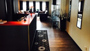 A modern kitchen with a wooden countertop and a dining area with a sofa. - Hotell Lyktan (Arjeplog)