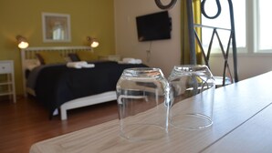 A room with a bed, a TV mounted on the wall, and two empty glasses on a table. - Hotell Lyktan (Arjeplog)