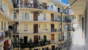 A multi-story building with balconies, air conditioning units, and potted plants. - Vantaggio Suites (Rome)