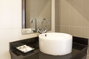 A bathroom with a white sink, a mirror, and a black countertop. - Lanta Lapaya Resort (Ko Lanta)