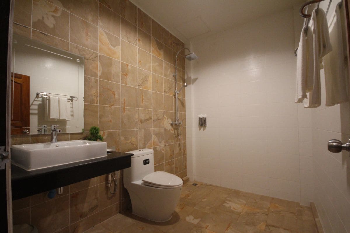 A bathroom with a sink, toilet, and shower.