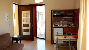 Un espacio habitable compacto con sofá, kitchenette y comedor.
