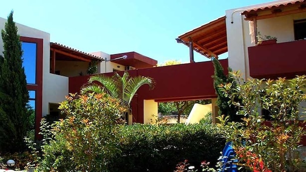 Un edificio moderno con balcones y un jardín.
