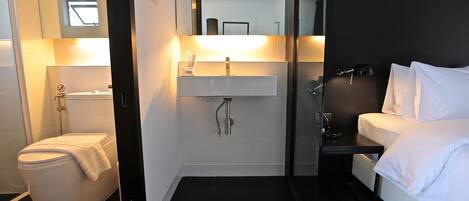 A modern bathroom with a toilet, sink, and shower area.