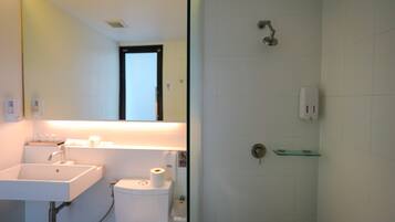 Un baño con lavamanos, inodoro y ducha.