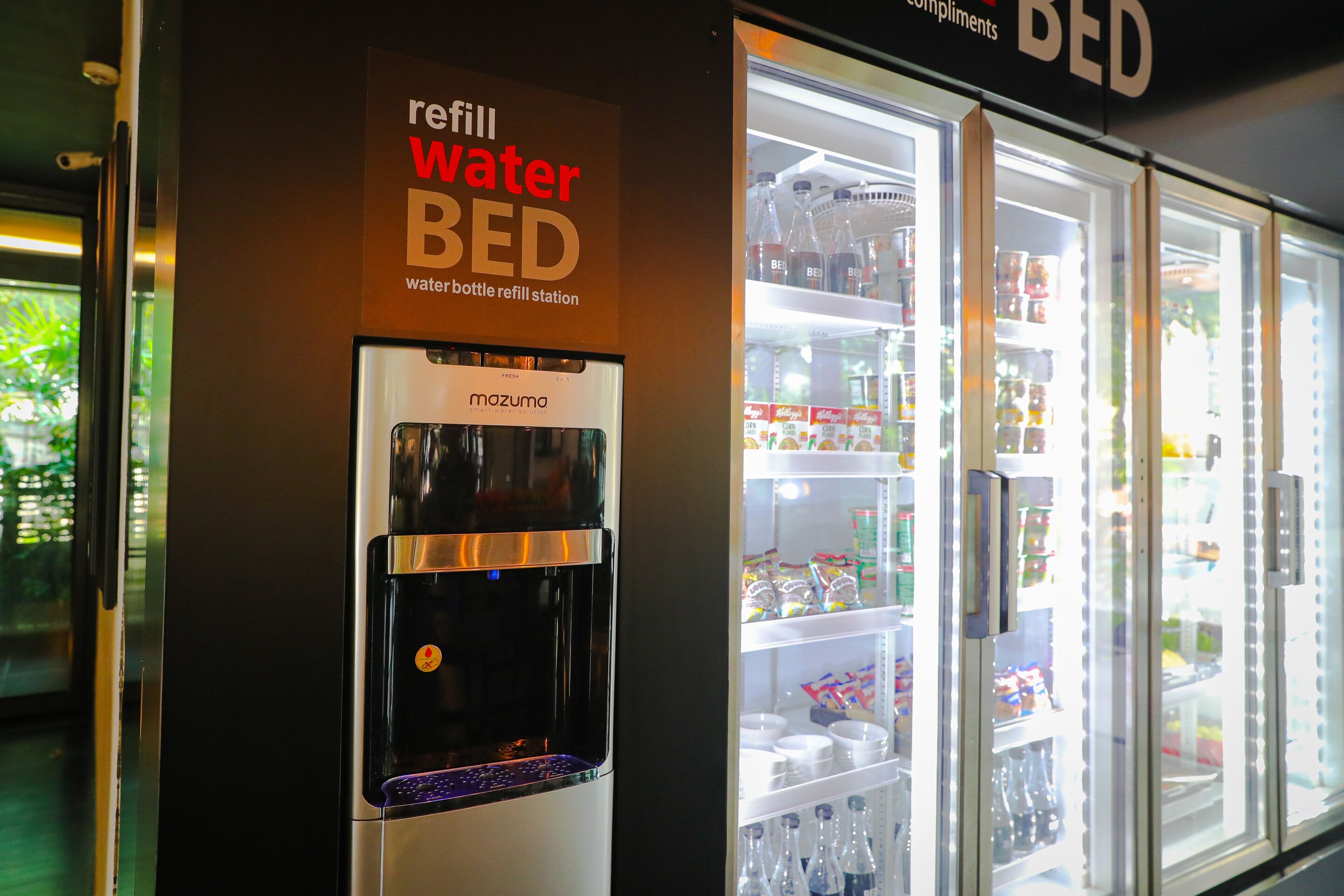 Una estación para rellenar botellas de agua y un refrigerador con bebidas.